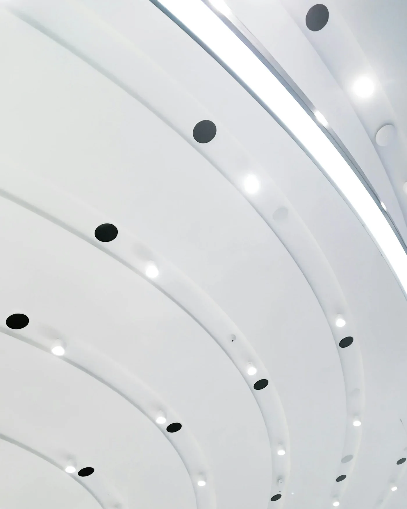 Heller Retail-Innenraum mit weißer metallischer Deckenstruktur, fotografiert von Baruch Pi